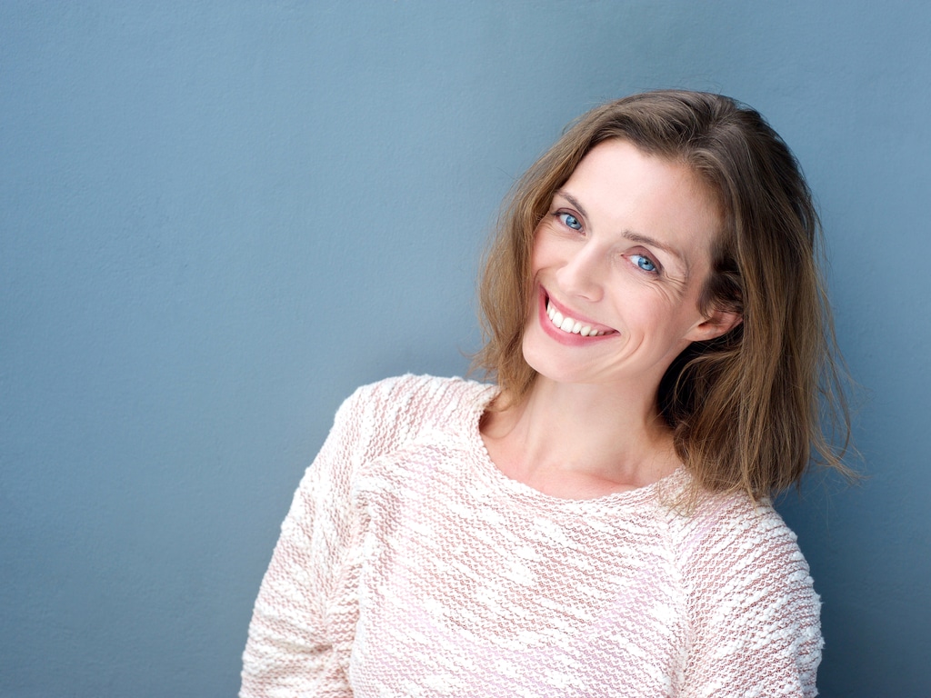 an attractive smiling mid adult woman on blue background