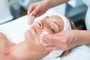 female patient having face cleaned before microdermabrasion