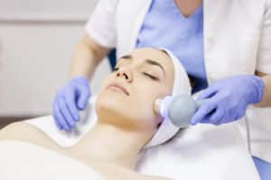 Face skin care. Woman getting facial laser treatment