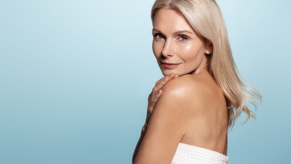 A woman looking over her shoulder, showing the results of IPL therapy in New York.