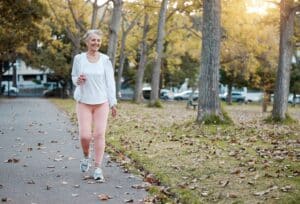 Elderly woman on walk feeling energized and strong after starting peptide therapy for age-related muscle loss.