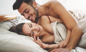 Woman holding hands around her midsection indicating a healthy gut Man and woman in bed after woman has the O-Shot in Williamsville, NY