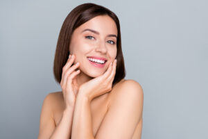 Woman holding hands around her midsection indicating a healthy gut Woman with fresh, glowing skin from microneedling with PRP in Williamsville, NY